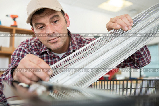 professional electrician fixing a heater. Стоковое фото, агентство Ingram Publishing / Фотобанк Лори