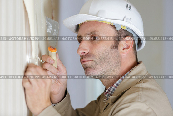 professional male stripping wallpaper with a scraper. Стоковое фото, агентство Ingram Publishing / Фотобанк Лори