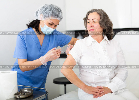 Professional nurse giving antiviral injection to aged woman. Стоковое фото, фотограф Яков Филимонов / Фотобанк Лори