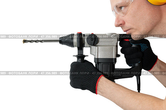 Professional worker with an impact drill in his hands on an isolated white background. Tool for drilling concrete and brick. Construction works. Стоковое фото, фотограф Дмитрий Кобзев / Фотобанк Лори