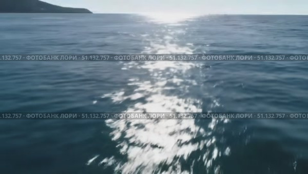 Пролетая над сияющей поверхностью моря крупный план, переливающаяся вода в солнечных лучах, видео океан. Стоковое AI-видео, аниматор Денис Костров / Фотобанк Лори