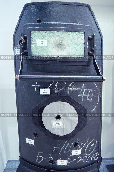 Protective shield for police and special forces with bullet damage. Bulletproof glass with holes from bullets Dragunov sniper rifle at exhibition Interpolitech - Moscow, Russia, 10 25 2019. Редакционное фото, фотограф Андрей Журавлев / Фотобанк Лори