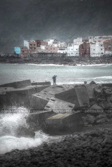 Puerto de la Cruz. fisherman standing on the dock and goes fishing. Big waves. Стоковое фото, агентство Ingram Publishing / Фотобанк Лори