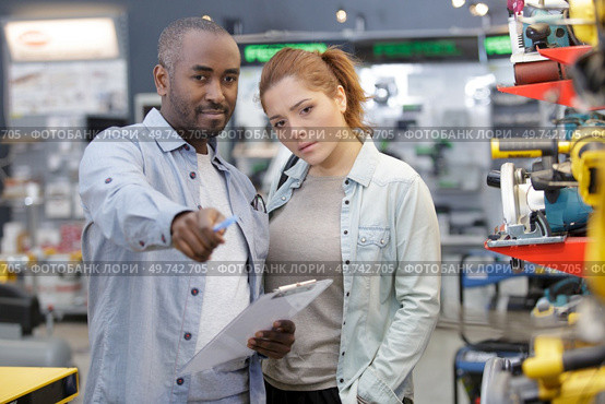 purchaser woman getting helped by assistant at hardware store. Стоковое фото, агентство Ingram Publishing / Фотобанк Лори
