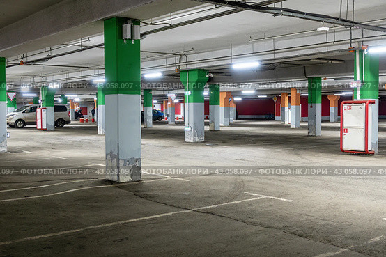 Пустая подземная парковка торгового центра.  Spacious underground parking of a modern shopping center. The parking lot is marked and has many free spaces for cars. Стоковое фото, фотограф Лариса Гордеева / Фотобанк Лори