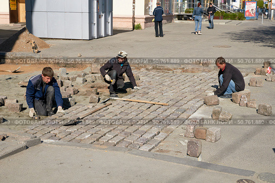 Рабочие кладут брусчатку в центре Калининграда (2011 год). Редакционное фото, фотограф Сергей Куров / Фотобанк Лори