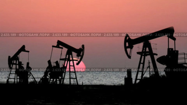 Работающие нефтяные насосы на фоне заходящего в море солнца. Стоковое видео, видеограф Михаил Коханчиков / Фотобанк Лори