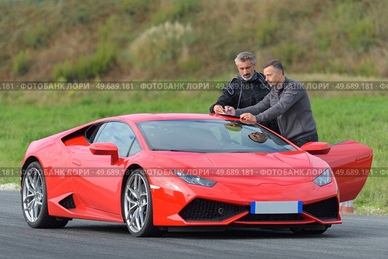 racing driver and coach stood by red sports car. Стоковое фото, агентство Ingram Publishing / Фотобанк Лори