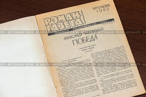 Раскрытый старинный журнал лежит на столе (2023 год). Редакционное фото, фотограф Игорь Низов / Фотобанк Лори