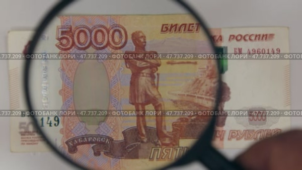 Рассматриваем с помощью лупы пятитысячную рублевую купюру. Понятие о финансах. Стоковое видео, видеограф Александр Собко / Фотобанк Лори