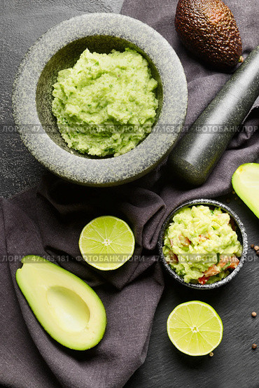 Раствор с вкусным гуакамоле, авокадо и лаймом на темном фоне. Стоковое фото, фотограф Pixel_shot / Фотобанк Лори