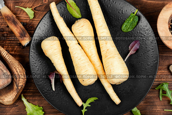 Raw and uncooked parsnips roots on the kitchen table. Fresh vegetable. Top view.. Close up parsnip. Стоковое фото, агентство Ingram Publishing / Фотобанк Лори