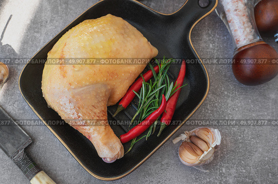 Raw chicken leg. A piece of fresh raw chicken leg with red chilli. displayed on a black stylish ceramic baking pan. Top view. Стоковое фото, фотограф Оксана Медведева / Фотобанк Лори