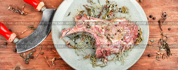 Raw pork steak Tomahawk marinated in spicy herbs on wooden background.. Raw pork steak Tomahawk. Стоковое фото, агентство Ingram Publishing / Фотобанк Лори