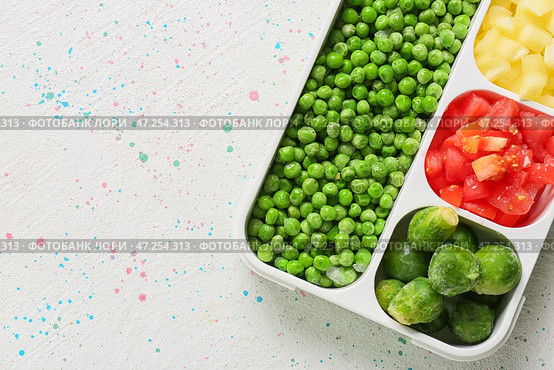 Разделенная коробка с разными замороженными овощами на белом фоне. Стоковое фото, фотограф Pixel_shot / Фотобанк Лори
