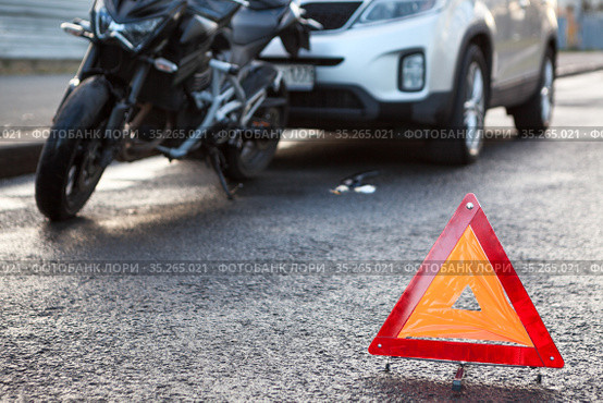 Rear-end collision on a road, suv car hits a motorcycle, emergency warning triangle is on asphalt roadside. Стоковое фото, фотограф Кекяляйнен Андрей / Фотобанк Лори