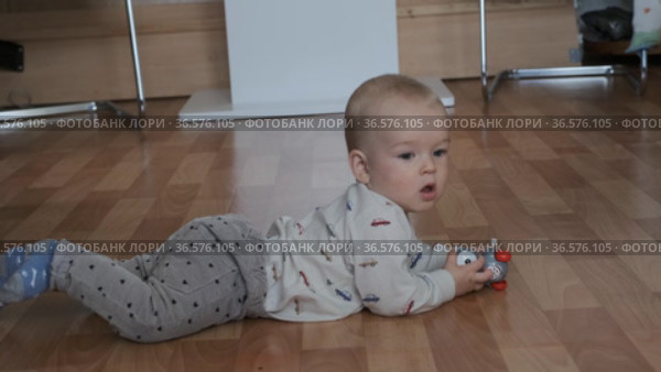 Ребенок учится ползать и играет в комнате на полу. Стоковое видео, видеограф Момотюк Сергей / Фотобанк Лори