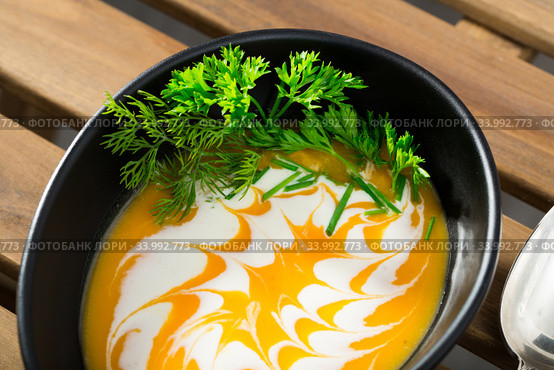 Recipe of pumpkin soup puree with ginger root - roast pumpkin in olive oil, beat in blender with vegetable broth. Add whisked cream with garlic and ginger. Serve with greens. Стоковое фото, фотограф Яков Филимонов / Фотобанк Лори