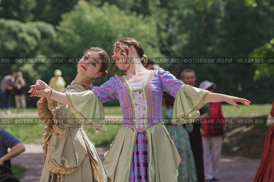 Reconstruction of the court ball of the mid-18th century of Her Imperial Majesty Catherine II in the Tsaritsyno Park in Moscow. Girls in ball gowns dance in the fresh air. (2023 год). Редакционное фото, фотограф Photojuli / Фотобанк Лори