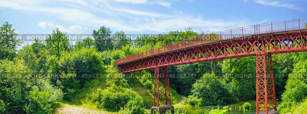 Red bridge in green nature with a river stream beneath in the summer. Стоковое фото, агентство Ingram Publishing / Фотобанк Лори