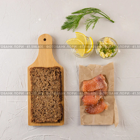 Red fish sandwich ingredients flatlay on a cement background. The products for burger tout, wholegrain bread, lemon, cheese, greens. Стоковое фото, фотограф Воловодов Владимир / Фотобанк Лори