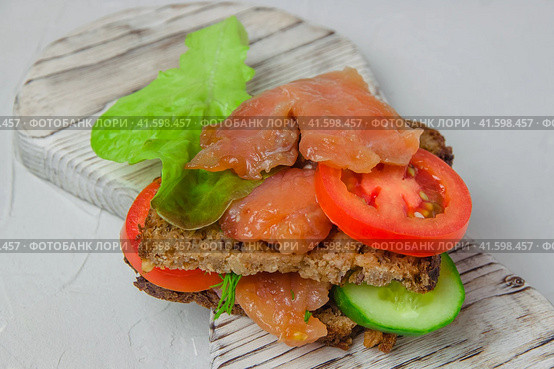 Redfish bread snack with salad, vegetables and herbs laying on a white rustic board. Стоковое фото, фотограф Воловодов Владимир / Фотобанк Лори