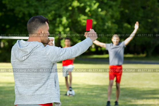 referee hands with red card on football field. Стоковое фото, агентство Ingram Publishing / Фотобанк Лори