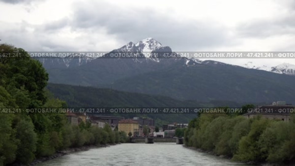Река Инн на фоне снежной вершины горы в городе Инсбрук. Австрия. Май. The Inn River against the backdrop of a snowy mountain peak in the city of Innsbruck. Austria. May. Стоковое видео, видеограф Горшков Александр / Фотобанк Лори