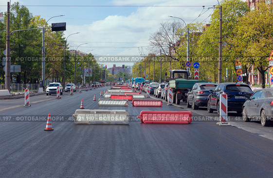 Ремонт городской дороги весной. Укладка асфальтобетонного покрытия на проспекте с интенсивным движением. Санкт-Петербург. Редакционное фото, фотограф Grigory_Gez / Фотобанк Лори