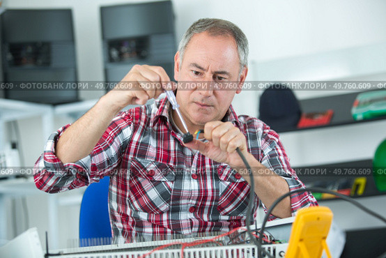repairer hands with screwdriver disassembling damaged unit for repair. Стоковое фото, агентство Ingram Publishing / Фотобанк Лори