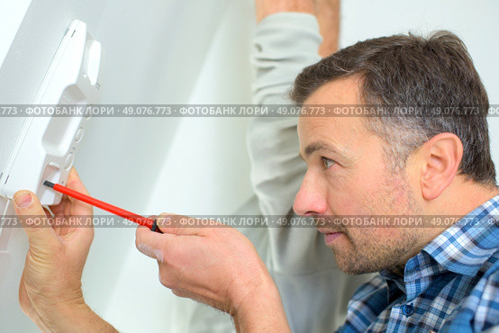 Repairing an intercom receiver. Стоковое фото, агентство Ingram Publishing / Фотобанк Лори