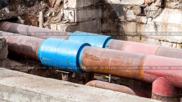 Replacement of heating pipes and modernization of the heating system in city. Construction works on large iron pipes at a depth of excavated trench. Стоковое видео, видеограф FotograFF / Фотобанк Лори