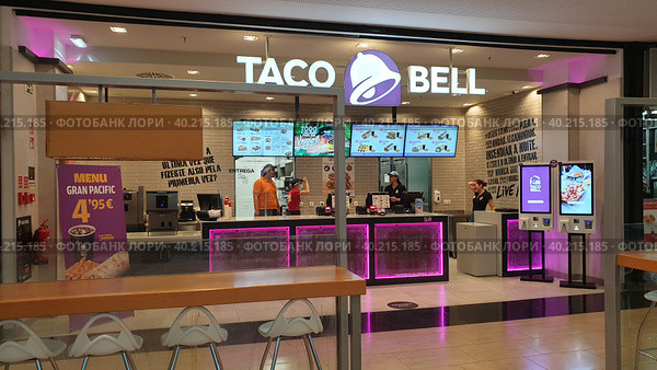 Ресторан быстрого питания адаптированной кухни текс-мекс Taco Bell. Торговый центр. Фуншал, Мадейра, Португалия (2023 год). Редакционное фото, фотограф lana1501 / Фотобанк Лори