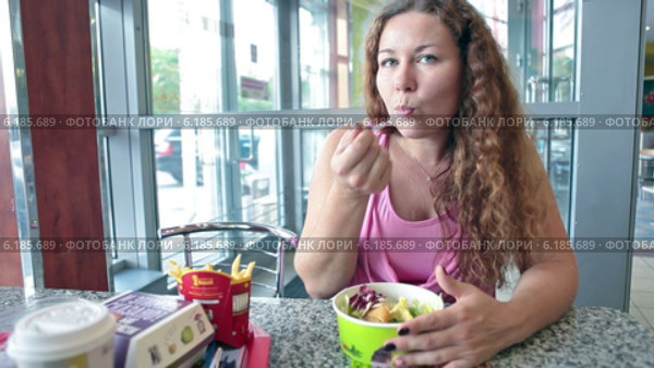 Ресторан McDonalds и девушка со стандартным набором фастфуда (2014 год). Редакционное видео, видеограф Кекяляйнен Андрей / Фотобанк Лори