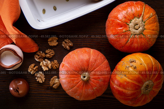ripe orange pumkins served at wooden brown table with  walnuts and coconut milk.  top view. healthy life concept. Стоковое фото, агентство Ingram Publishing / Фотобанк Лори