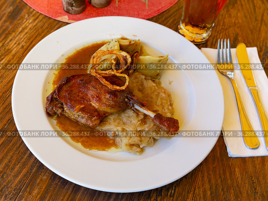 Roasted confit du canard with sauerkraut, potato dumplings and onion. Стоковое фото, фотограф Яков Филимонов / Фотобанк Лори