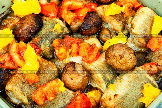 Roasted hake fish with orange, tomato and mushrooms. Food background. Baked dietary sea fish hake,macro. Стоковое фото, агентство Ingram Publishing / Фотобанк Лори