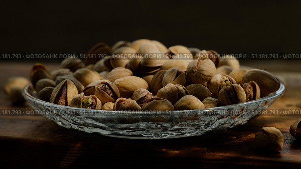 Roasted pistachios nuts in plate on dark background. Стоковое фото, фотограф Маргарита Кирьякова / Фотобанк Лори