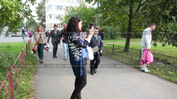Родители провожают своих детей первоклассников на торжественную линейку перед школой. 1 Сентября. День Знаний. Санкт-Петербург (2015 год). Редакционное видео, видеограф Кекяляйнен Андрей / Фотобанк Лори