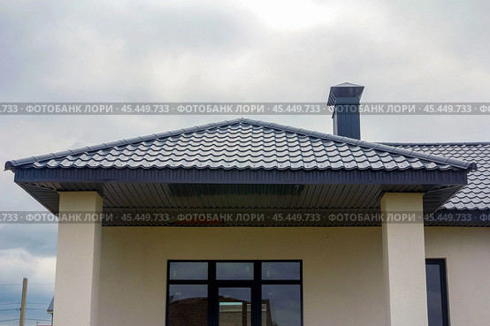 roof of a new private house against the background of a cloudy sky on a summer day. Стоковое фото, фотограф Акиньшин Владимир / Фотобанк Лори