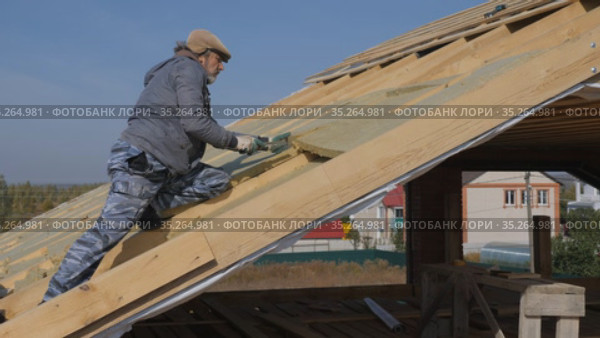 Roofing work. Installation of insulation for insulation of the roof of a private house. Стоковое видео, видеограф Константин Мерцалов / Фотобанк Лори