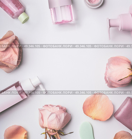 Roses cosmetics frame with toner,serum, essence,moisturizer and others on white desktop background, top view. Facial Skin care beauty treatment. Стоковое фото, агентство Ingram Publishing / Фотобанк Лори