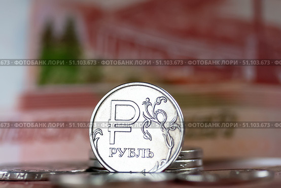 Российские деньги: Блестящая монета один рубль на фоне пятитысячной купюры. Крупный план. Малая глубина резкости. Стоковое фото, фотограф Лариса Гордеева / Фотобанк Лори