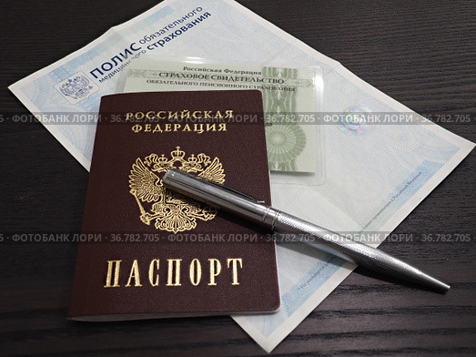 Российский паспорт с полисом ОМС и СНИЛС на деревянном столе. Стоковое фото, фотограф Алексей Кононов / Фотобанк Лори