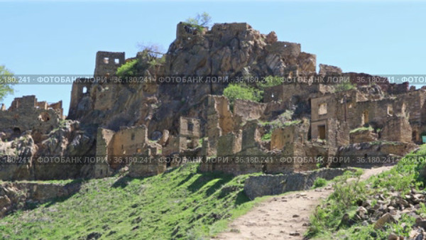 Ruins of ancient Gamsutl village with abandoned building stone walls on mountain slope cliff on sunny day in Dagestan Russia (2021 год). Стоковое видео, видеограф Алексей Кузнецов / Фотобанк Лори