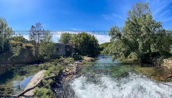 Rushing river Ancora in Portugal, with rapids flows past an old stone house nestled amongst lush greenery. Стоковое фото, агентство Ingram Publishing / Фотобанк Лори
