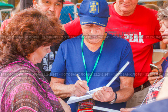 Russia, Samara, July 2016: Distribution of Alexander Gorodnitsky's autographs, at the Grushinsky festival on Mastryukovskie lakes on a summer day. Редакционное фото, фотограф Акиньшин Владимир / Фотобанк Лори