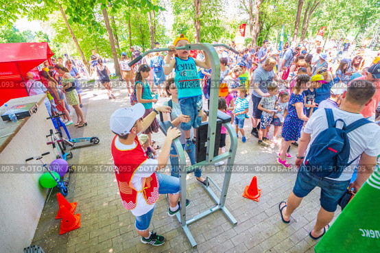 Russia Samara June 2019: a girl passes the standards for pulling up on a horizontal bar in the park sunny day. Text in Russian: Judge Gto. Редакционное фото, фотограф Акиньшин Владимир / Фотобанк Лори