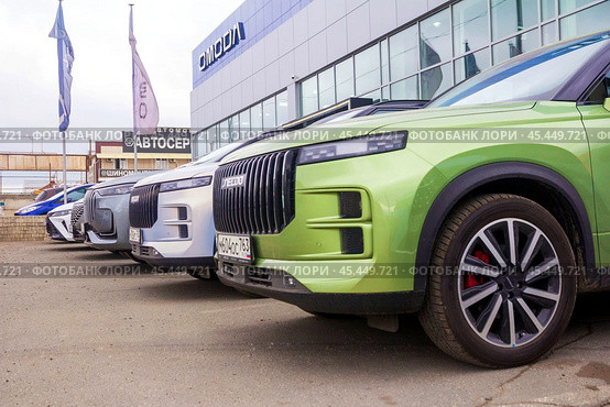 Russia. Samara, June 28, 2024: Chinese cars from the Amoda company are standing near the car dealership for sale. text in Russian: tire service car service. Редакционное фото, фотограф Акиньшин Владимир / Фотобанк Лори