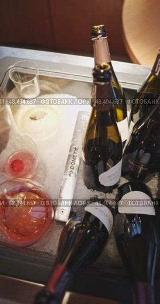 Russia, St.Petersburg, 24 April 2025: Several bottles of champagne brand Bonnet-Ponson are cooled in a niche with ice in the restaurant, local lighting, wine cabinet, decanters for sparkling wine. Редакционное видео, видеограф Vladimir Drozdin / Фотобанк Лори